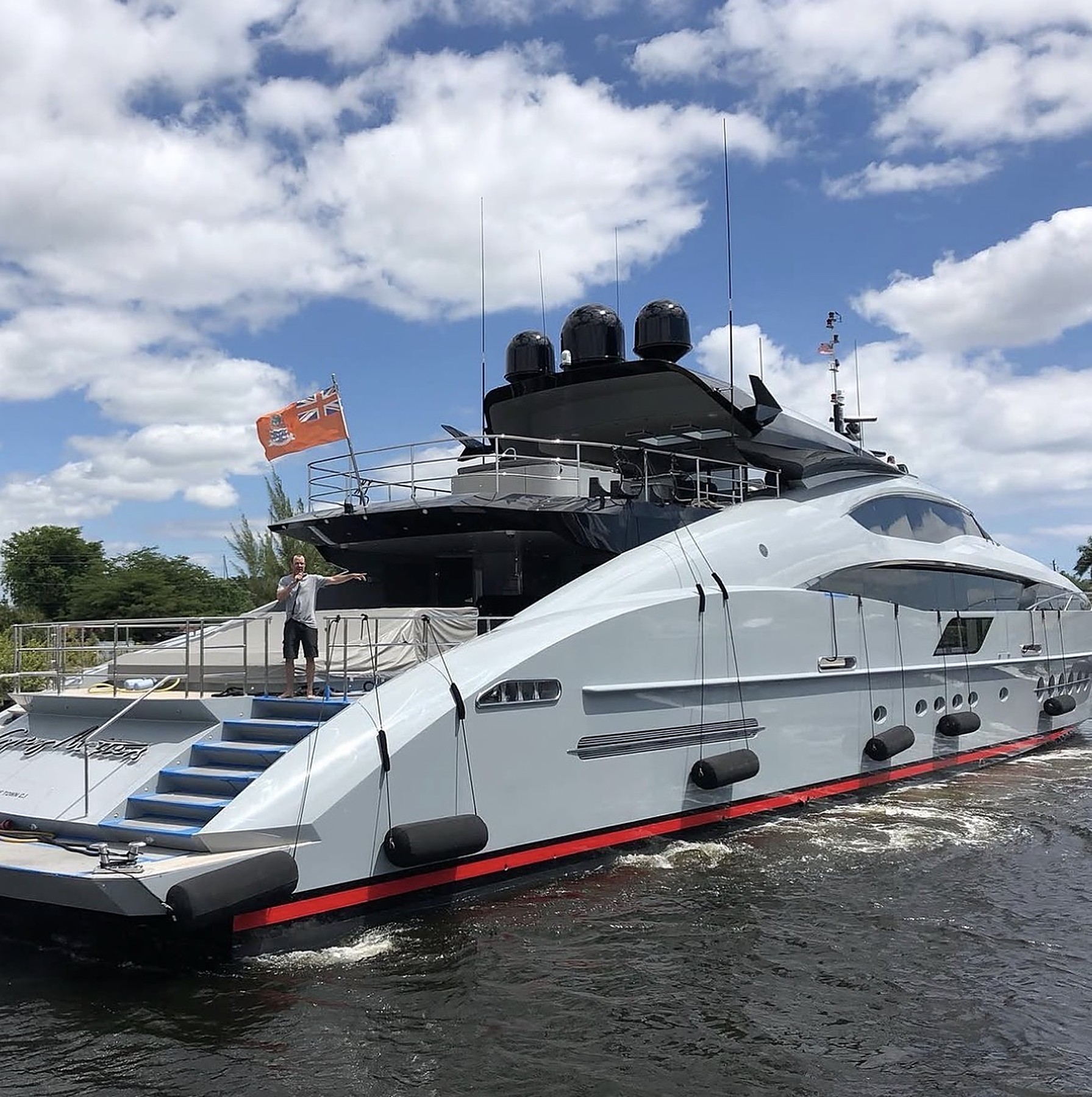 Grey and white motor yacht with a freshly finished hull underway on the waterway