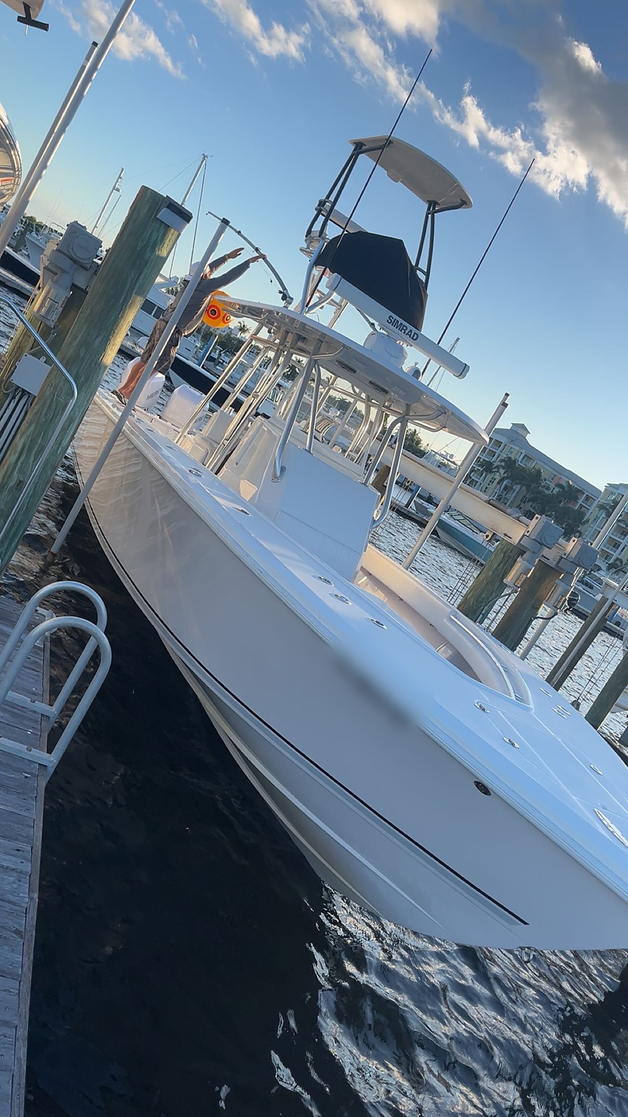 Detailed white center console fishing boat tied up at a South Florida dock