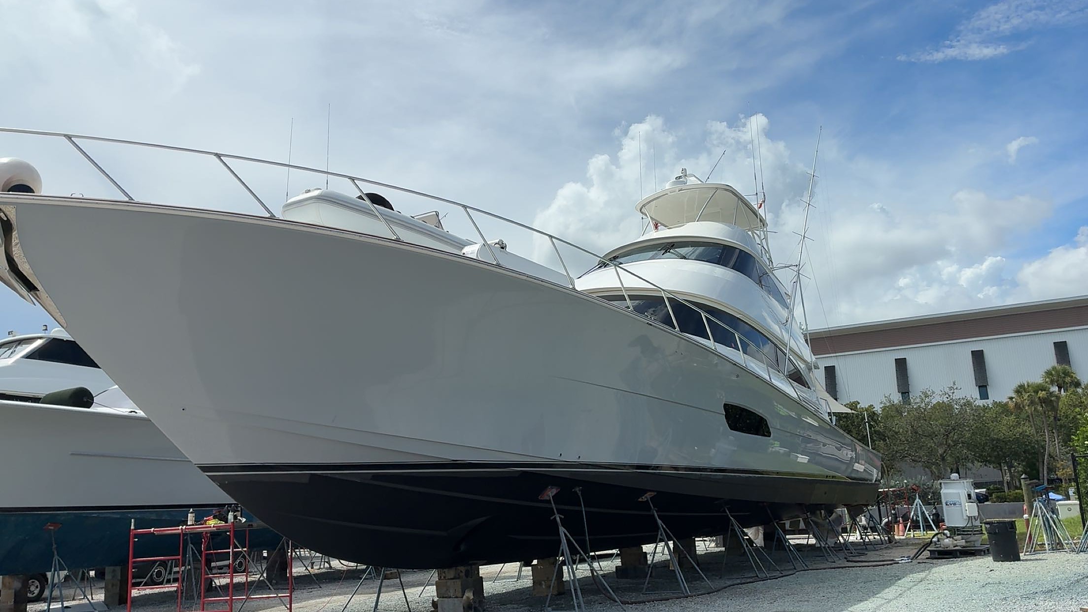 Sportfish yacht with a glossy hull on stands in a boatyard